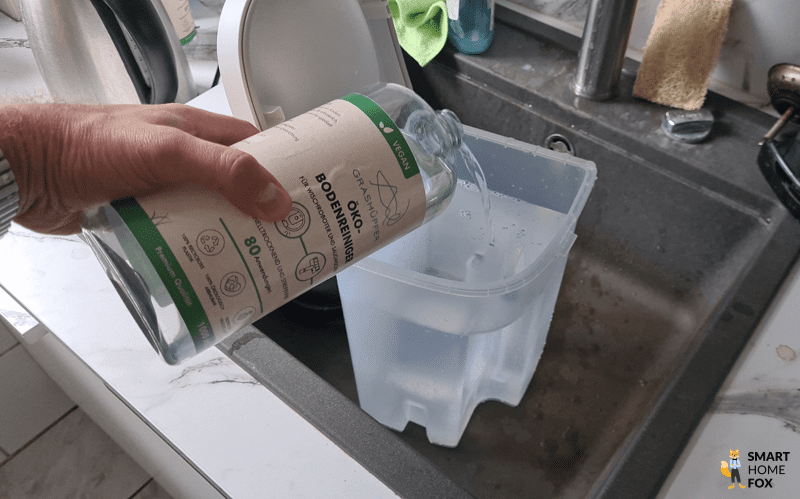 Ein Reinigungsmittel wird in den Frischwassertank des Roborock Qrevo hinzugegeben.